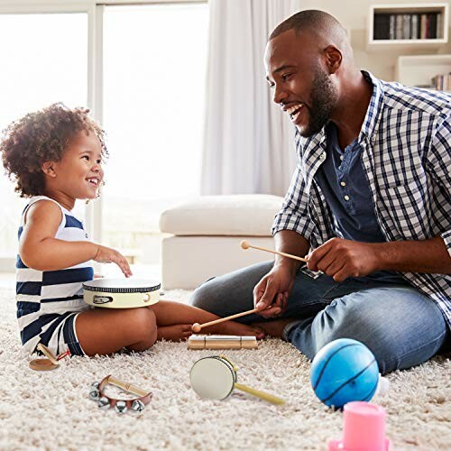 Father and child playing musical instruments on a carpet.