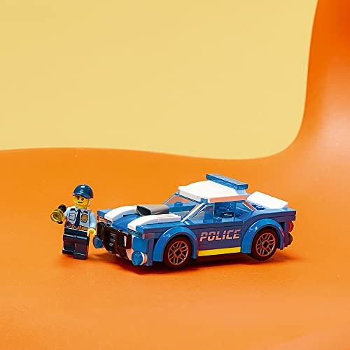 LEGO police car with figurine on orange background